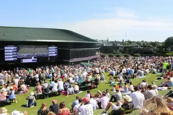 wimbledon crowds outside the court watching a tennis match on screen