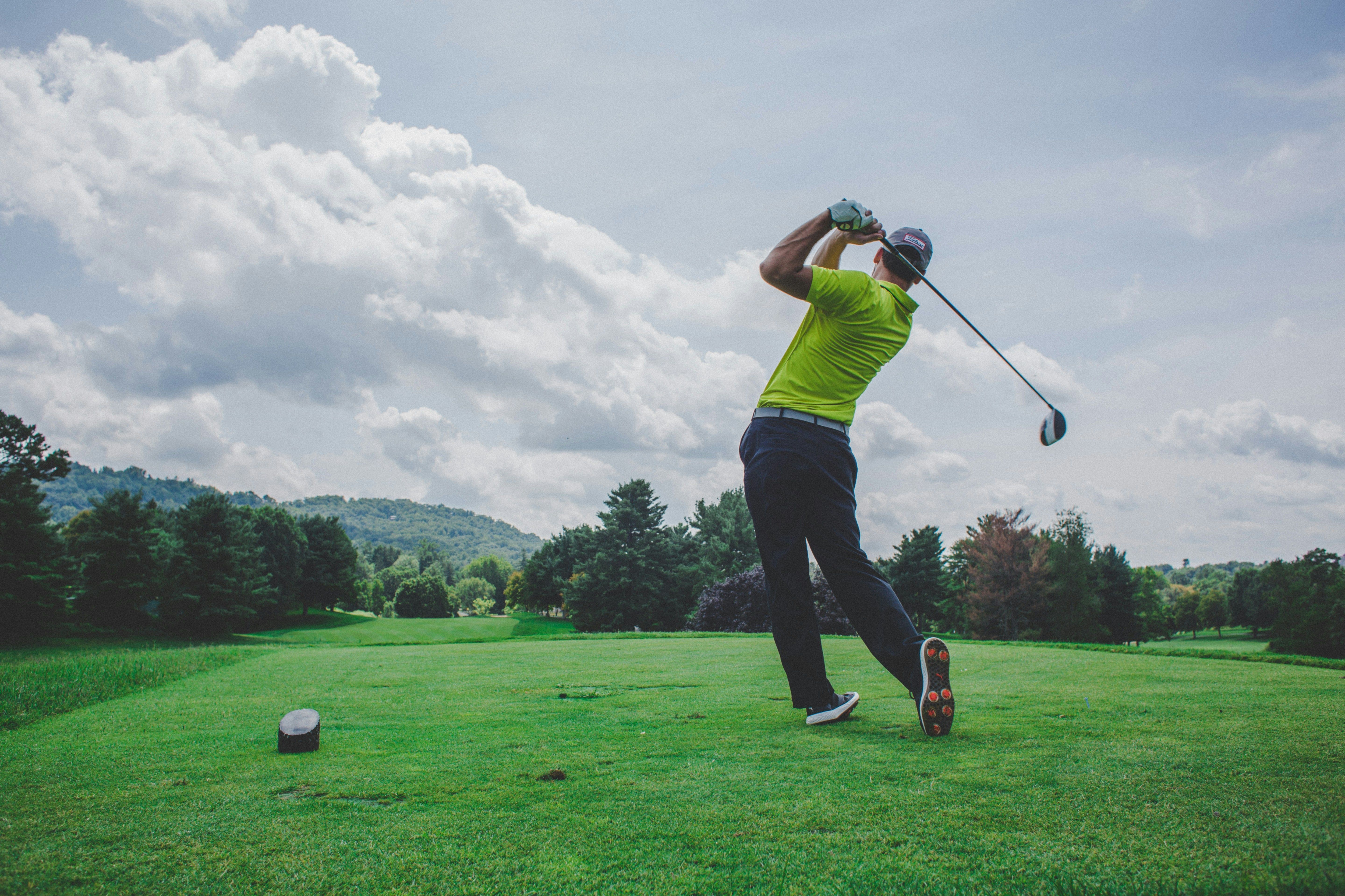 A man playing golf on green grass.