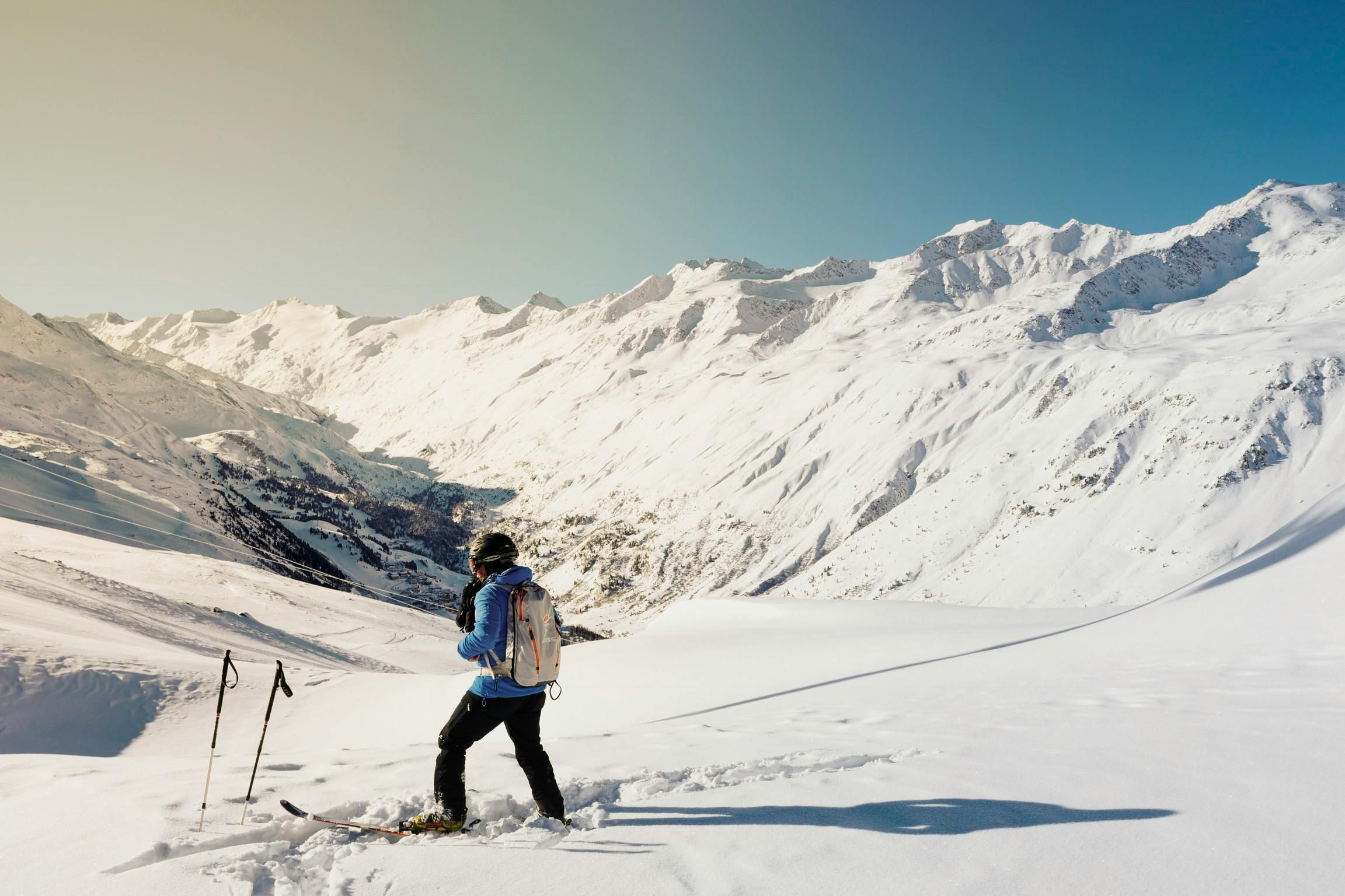 A skier at the top of a snowy mountain, just soaking in the view.
