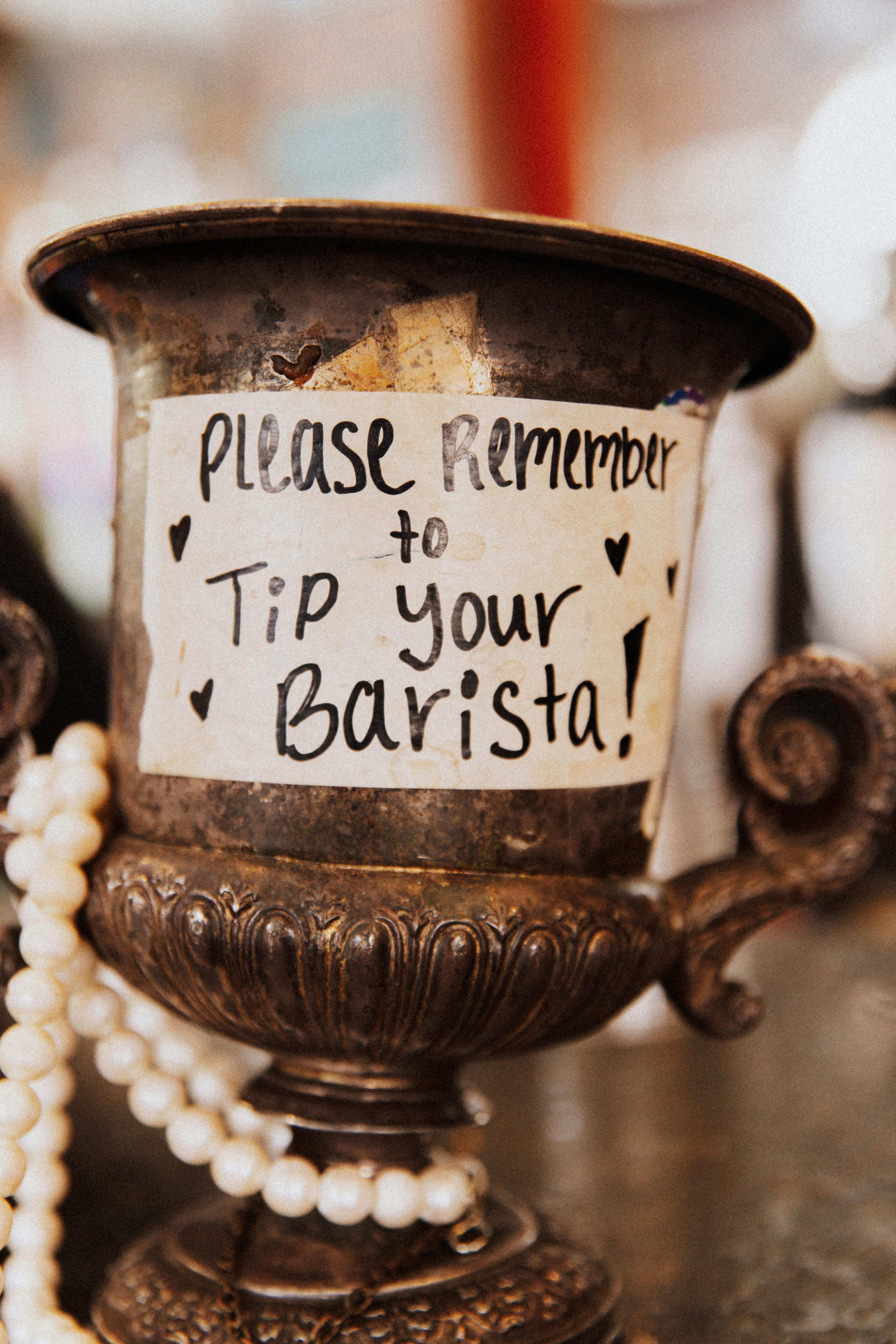tipping culture in the usa - tip jar that reads please remember to tip your barista