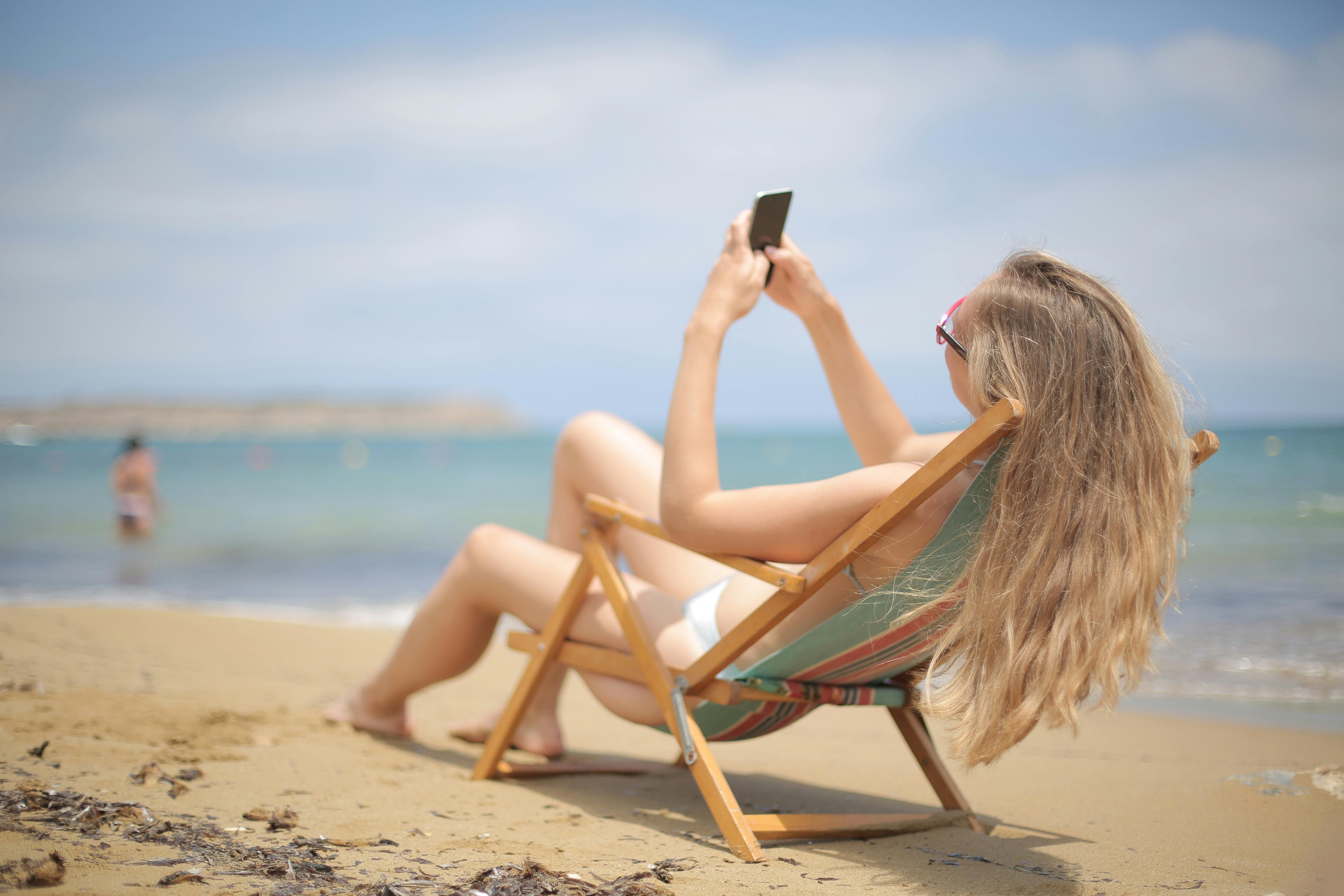 woman on beach using her phone